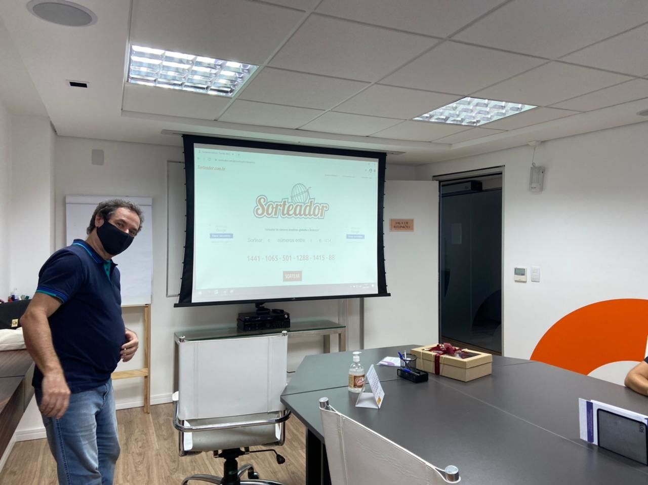 Diretor da ELOS fazendo o sorteio na sala de reuniões